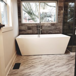 A modern bathroom interior featuring waterproof bathroom vinyl plank flooring guide Lancaster PA style with a wood-look finish