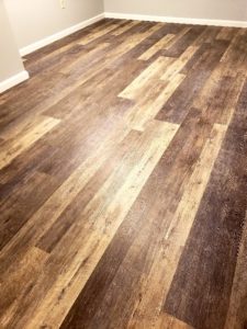 A completed kitchen and bathroom flooring installation in a modern open-concept home