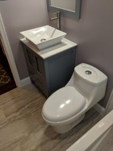 A modern bathroom interior featuring waterproof bathroom vinyl plank flooring guide Lancaster PA style with a wood-look finish