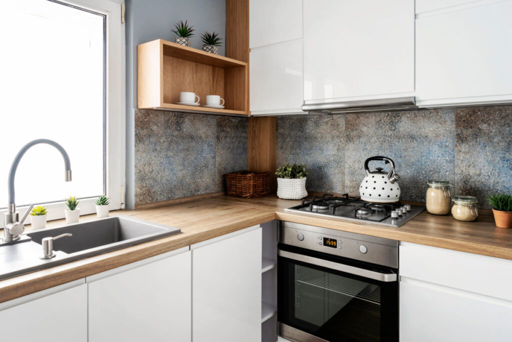 small kitchen design with clean wood countertops and shiny white cupboards that make the space feel more spacious