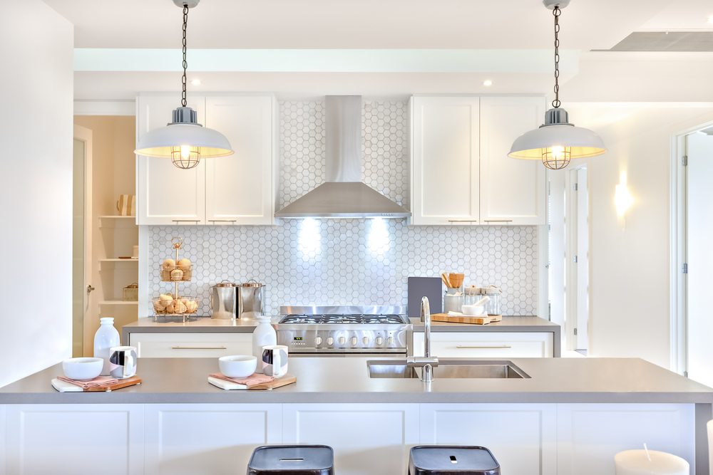 kitchen lighting in a newly renovated space - lights above the stove and hanging over the kitchen island