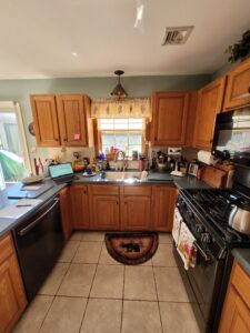 A luxury kitchen showcasing modern kitchen design trends 2025 with deep green cabinetry and gold accents.